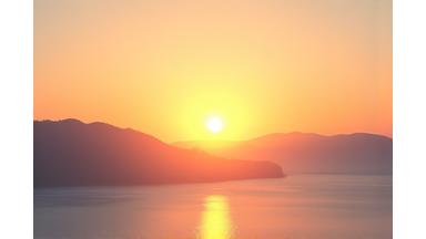 Sunrise over a calm lake, representing morning energy and new beginnings.