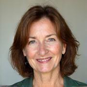 Professional headshot of Coach Elara Vance, a warm, experienced woman.